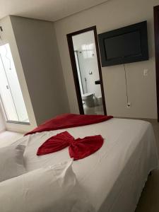 sypialnia z łóżkiem z czerwoną kokardą w obiekcie Hotel Cristalina w mieście Cristalina