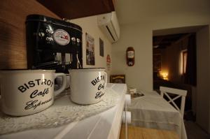 dos tazas de café sentadas en un mostrador junto a una cafetera en Villa Rusztika, en Gyula