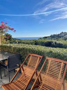 2 sillas de madera sentadas junto a una mesa en Spa & vue Mer - Les Ô de Bandol, en Bandol