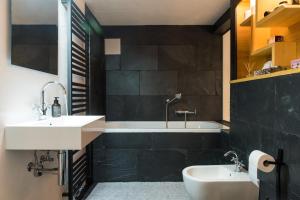 La salle de bains est pourvue d'un lavabo blanc et d'une baignoire. dans l'établissement Design Loft I 130 qm I 22 min zum Europapark I 2 Etagen I Nespresso I Parkplatz, à Lahr/Schwarzwald