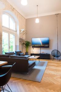 sala de estar con sofá y TV en la pared en Design Loft I 130 qm I 22 min zum Europapark I 2 Etagen I Nespresso I Parkplatz, en Lahr