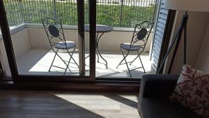 a porch with two chairs and a table on a balcony at Nuevo departamento con estacionamiento y a pasos del centro de Puerto Varas in Puerto Varas