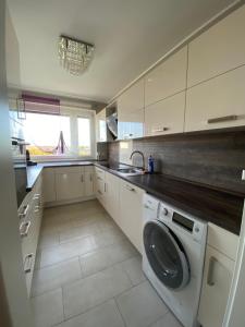 a white kitchen with a washing machine in it at Luxus Wohnung & Apartment nähe Hannover & Messe in Hannover