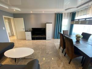 a living room with a table and chairs and a television at Luxus Wohnung & Apartment nähe Hannover & Messe in Hannover