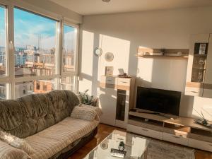 a living room with a couch and a large window at Stan na dan Bella in Banja Luka