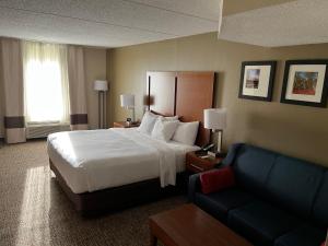 a hotel room with a bed and a couch at Wingate by Wyndham Clearfield in Clearfield