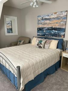 a bedroom with a large bed with a painting on the wall at Lakeville Executive Home with every amenity, prime location in Lakeville