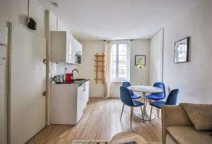 eine Küche mit einem Tisch und blauen Stühlen in einem Zimmer in der Unterkunft 11#Appartement 4Pers#Sèvres-Lecourbe#Necker in Paris