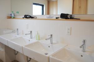 a bathroom with three sinks and a mirror at 04 village Namba - Vacation STAY 37120v in Osaka