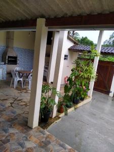 un patio con macetas y una mesa en Ótima localização em Ubatuba, en Ubatuba 2 fotos más