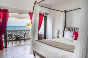 1 dormitorio con 1 cama y vistas al océano en Sand and Tan Beach Hotel, en Ocho Ríos