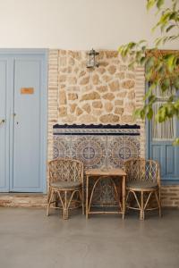 stół i dwa krzesła obok ściany z cegły w obiekcie CASA SIRFANTAS w Kordobie