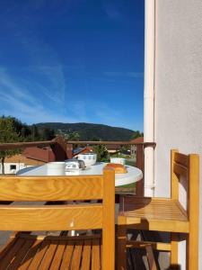 a table and chairs on a balcony with a pizza on it at Bel appartement dans une ferme Vosgienne in Xonrupt-Longemer