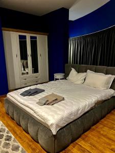 un grande letto in una camera da letto con parete blu di ROOF TOP LUXURY a Blagoevgrad