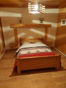 sypialnia z drewnianym łóżkiem w pokoju w obiekcie Bel appartement dans une ferme Vosgienne w mieście Xonrupt-Longemer +15 zdjęć
