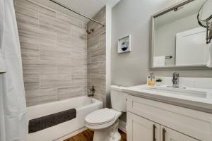 biała łazienka z umywalką, toaletą i wanną w obiekcie The Brilliant Flat Arboretum Tickets Included w mieście Dallas