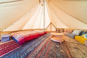 OKAYAMA GLAMPING SORANIA - Vacation STAY 73233v في كوراشيكي: خيمة بسرير وطاولة وسجادة