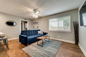 a living room with a blue couch and a table at The Brilliant Flat Arboretum Tickets Included in Dallas