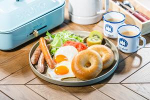 un piatto di prodotti per la colazione con uova e bagel su un tavolo di OKAYAMA GLAMPING SORANIA - Vacation STAY 73233v a Kurashiki