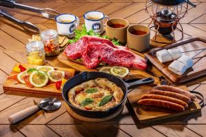 OKAYAMA GLAMPING SORANIA - Vacation STAY 73233v في كوراشيكي: طاولة مليئة بالطعام مع وعاء من المواد الغذائية واللحوم