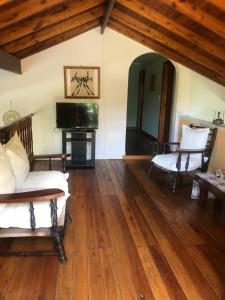 uma sala de estar com pisos em madeira e uma televisão em EL PARAISO DEL DESCANSO em Sierra de los Padres