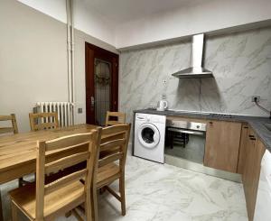 - une cuisine avec une table et un lave-linge/sèche-linge dans l'établissement Piso reformado en el centro de Logroño, à Logroño