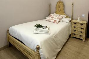 - une chambre avec un lit doté d'un cadre en or et une commode dans l'établissement Piso reformado en el centro de Logroño, à Logroño