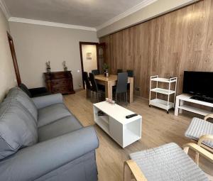 - un salon avec un canapé et une table avec une télévision dans l'établissement Piso reformado en el centro de Logroño, à Logroño