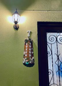 a light on a green wall with a bag on it at Luxury Tugurio in Arma di Taggia
