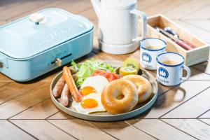 un piatto di prodotti per la colazione con uova e bagel su un tavolo di OKAYAMA GLAMPING SORANIA - Vacation STAY 19628v a Kurashiki