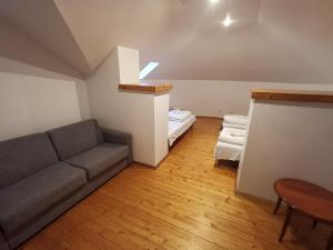 uma sala de estar com um sofá e uma cama em A&L private rooms in Kaunas em Kaunas