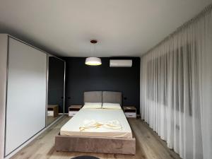 AmIon Apartment in Center of Tirana في تيرانا: غرفة نوم مع سرير مع قوس عليه