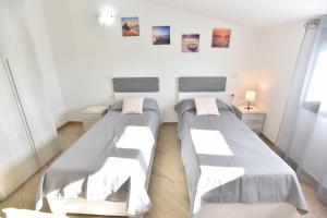 two beds in a room with white walls at Casa Terra Del Sole in Pula