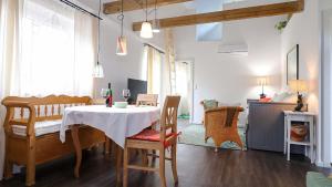 a dining room with a table and chairs and a living room at Urlaub am Kinispa in Hannersdorf