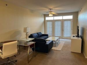 ein Wohnzimmer mit einem Sofa und einem TV in der Unterkunft WASHBURN HOTEL SUITES in Topeka