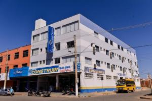 un edificio blanco con una furgoneta amarilla estacionada frente a él en Gran Norte Hotel - Salinas - MG, en Salinas