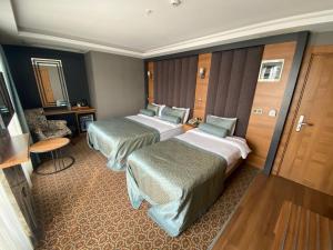 a hotel room with two beds and a table at Green Prusa Hotel in Bursa