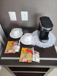 a table with a coffee maker and food on it at Motel Real de Queretaro in Querétaro
