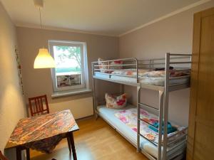 Kleines Zimmer mit 2 Etagenbetten und einem Tisch in der Unterkunft Bastorf Sea View Escape in Bastorf