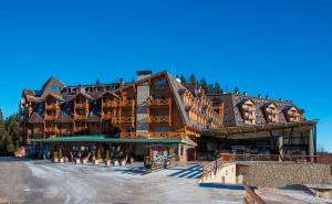 a large wooden building with a ski lodge at Apartman B428 Vucko in Jahorina