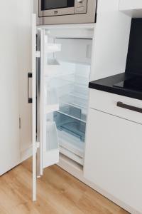 a refrigerator with its door open in a kitchen at Louis & Louise Apartments & Rooms I Digital Check In in Bremen