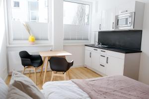 a bedroom with a bed and a table and chairs at Louis & Louise Apartments & Rooms I Digital Check In in Bremen