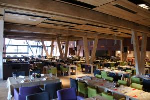 a dining room with tables and chairs in a building at Apartman B428 Vucko private host in Jahorina