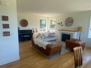 uma sala de estar com um sofá e uma lareira em Big 4 Bd, 4 Ba home, Steps to Ocean with EV Charger em Cowichan Bay