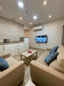 a large living room with two couches and a kitchen at همس المدى للشقق المخدومه in Al Ahsa