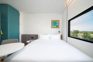 a room with two beds and a window at GO! Hotel Bowin at Robinson Lifestyle Bowin in Si Racha