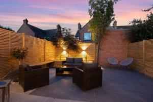 a patio with a fence and chairs and a couch at 'Modern Living in Old Town Stratford-upon-Avon' in Stratford-upon-Avon
