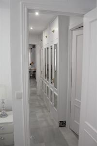 a hallway with white walls and a white door at Panther Home Sierpes in Seville