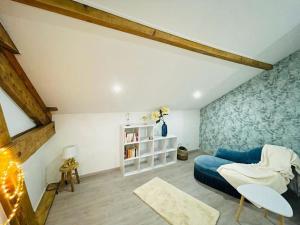 a living room with a blue couch and a table at Superbe appartement avec salle de jeux in Vaux-lès-Saint-Claude