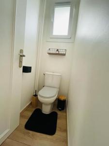 a small bathroom with a toilet and a window at Superbe appartement avec salle de jeux in Vaux-lès-Saint-Claude